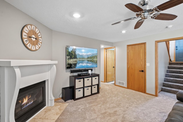 14380 Geneva Ave N, Hugo, MN 55038 - carpeted living room featuring ceiling fan, a glass covered fireplace, stairs, recessed lighting, and a textured ceiling
