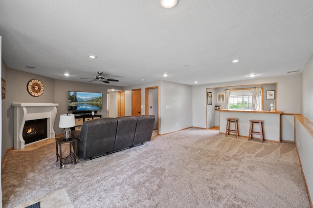 14380 Geneva Ave N, Hugo, MN 55038 - carpeted living room with baseboards, a ceiling fan, recessed lighting, a fireplace with flush hearth, and a textured ceiling