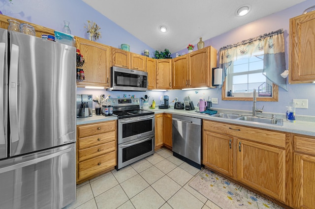 1320 18th St SE, Owatonna, MN 55060 - kitchen with appliances with stainless steel finishes, a sink, light countertops, lofted ceiling, and light tile patterned flooring