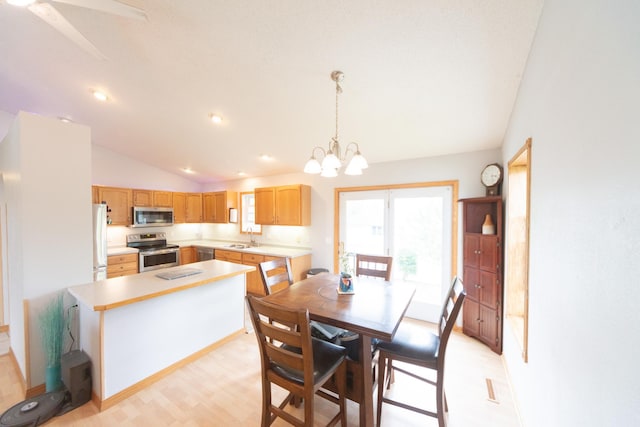 1320 18th St SE, Owatonna, MN 55060 - dining space featuring vaulted ceiling, a chandelier, and light wood-style floors