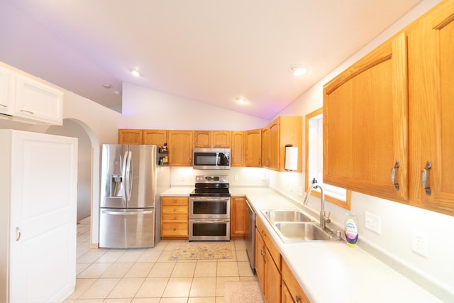 1320 18th St SE, Owatonna, MN 55060 - kitchen with appliances with stainless steel finishes, light countertops, vaulted ceiling, light tile patterned floors, and arched walkways