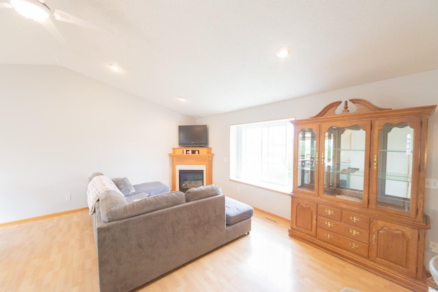 1320 18th St SE, Owatonna, MN 55060 - living area with light wood finished floors, vaulted ceiling, a glass covered fireplace, a ceiling fan, and recessed lighting