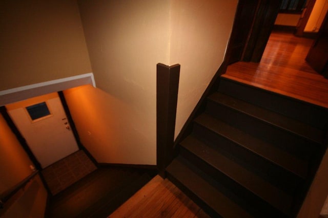 stairway with wood finished floors and baseboards
