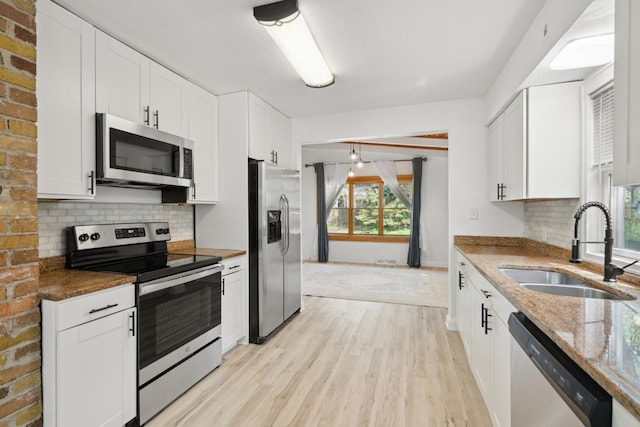 1775 Morgan Ave, Saint Paul, MN 55116 - kitchen with appliances with stainless steel finishes, a sink, light wood-style flooring, light stone countertops, and white cabinets