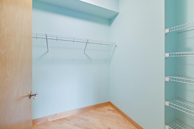 walk in closet with wood finished floors