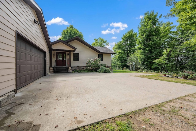 view of property exterior with driveway and an attached garage
