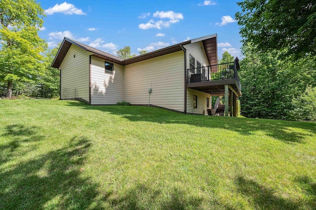 rear view of property featuring stairs, a deck, and a yard