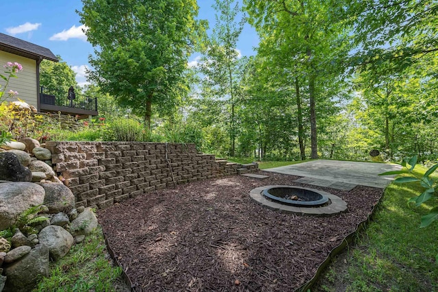 view of yard with a deck and a fire pit