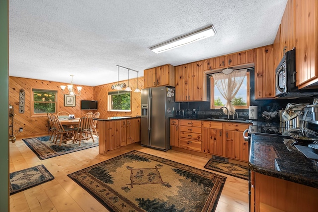kitchen featuring a sink, black microwave, stainless steel fridge with ice dispenser, and a healthy amount of sunlight