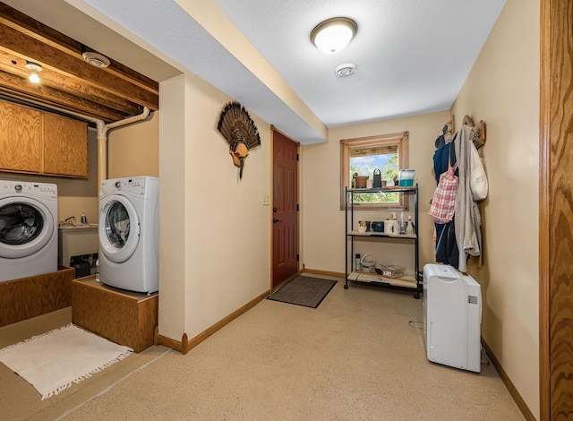 laundry room with washing machine and clothes dryer, cabinet space, and baseboards