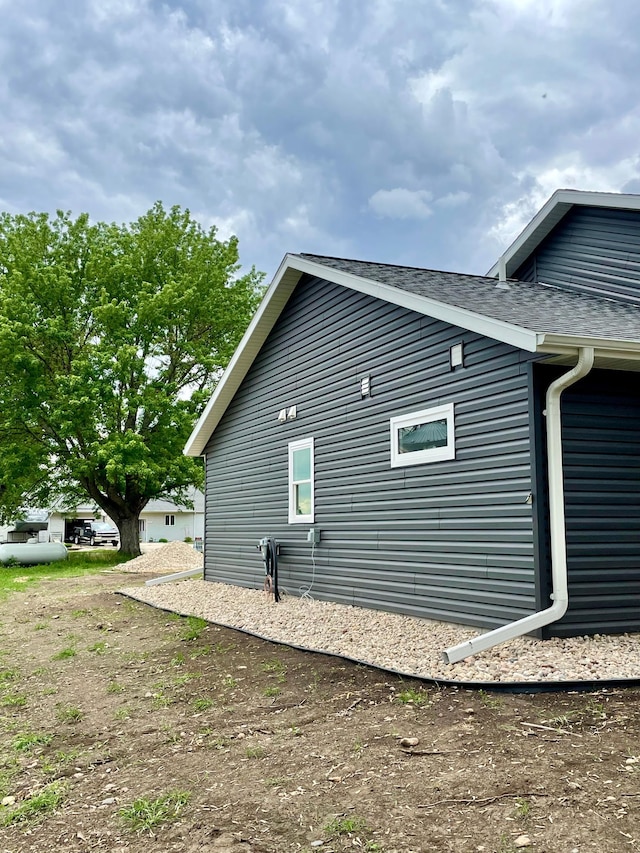 view of side of home featuring roof with shingles