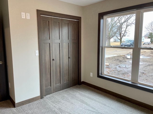 unfurnished bedroom featuring carpet flooring, a closet, and baseboards