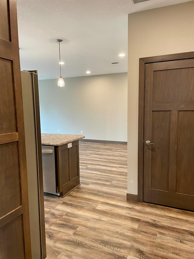 kitchen featuring baseboards, recessed lighting, light wood-type flooring, and dishwasher