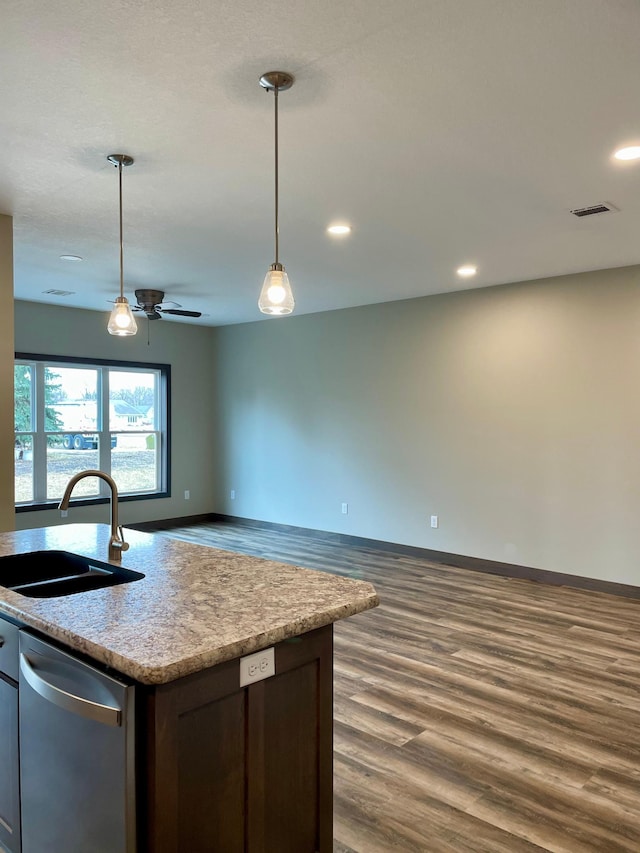 kitchen with a sink, pendant lighting, visible vents, dark wood-style flooring, and dishwasher