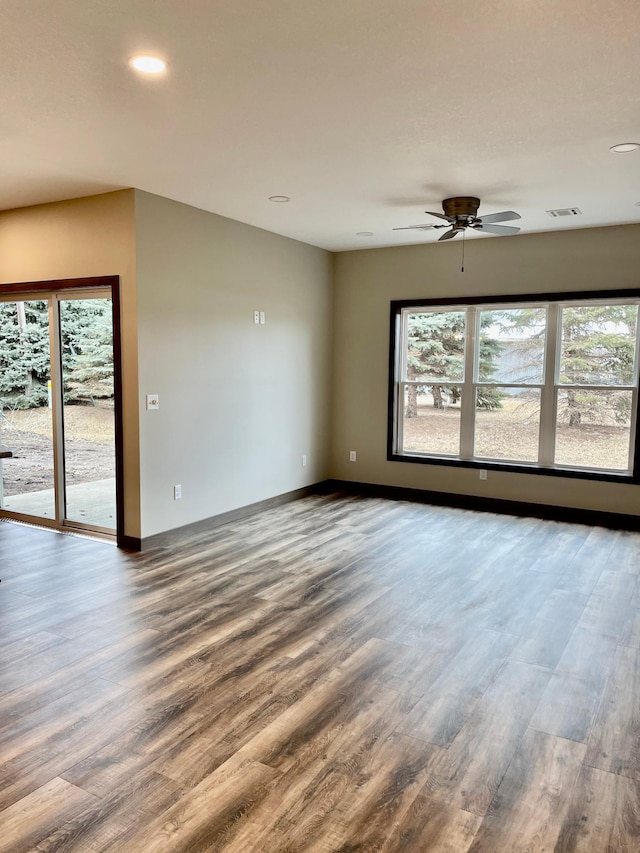 unfurnished room featuring a wealth of natural light, visible vents, and wood finished floors
