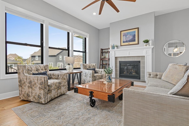 4152 Hummingbird Ct N, Lake Elmo, MN 55042 - living room featuring ceiling fan, wood finished floors, baseboards, a tiled fireplace, and recessed lighting
