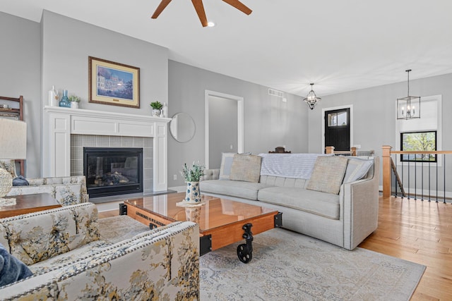 4152 Hummingbird Ct N, Lake Elmo, MN 55042 - living area with ceiling fan, light wood-style floors, a tiled fireplace, a chandelier, and recessed lighting