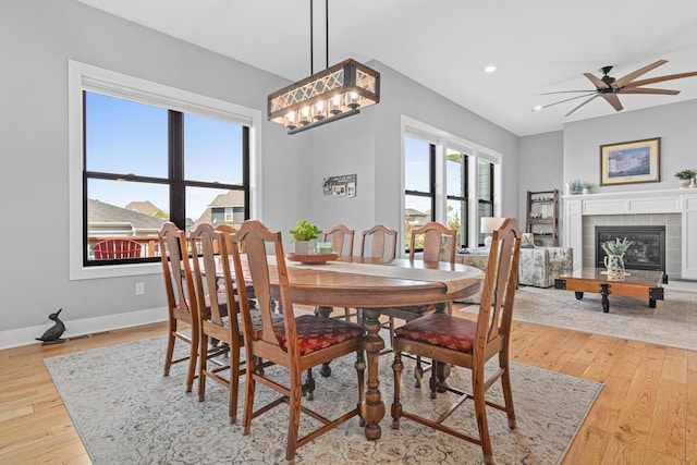 4152 Hummingbird Ct N, Lake Elmo, MN 55042 - dining room with light wood-style flooring, ceiling fan, recessed lighting, baseboards, and a tiled fireplace