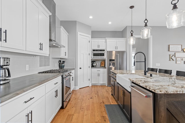 4152 Hummingbird Ct N, Lake Elmo, MN 55042 - kitchen featuring high quality appliances, a sink, white cabinetry, light wood-type flooring, and recessed lighting