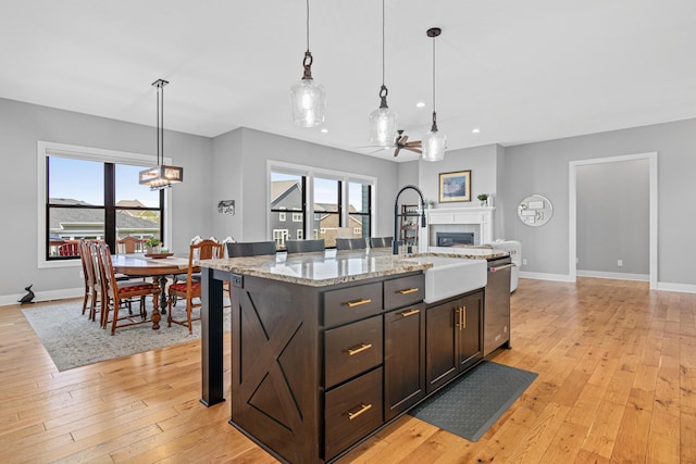 4152 Hummingbird Ct N, Lake Elmo, MN 55042 - kitchen featuring a fireplace, stainless steel dishwasher, baseboards, recessed lighting, and a sink
