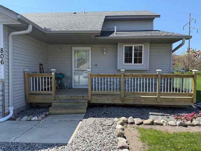 rear view of house with roof with shingles and a deck