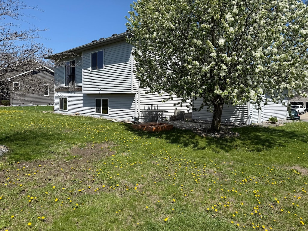 rear view of property featuring a lawn