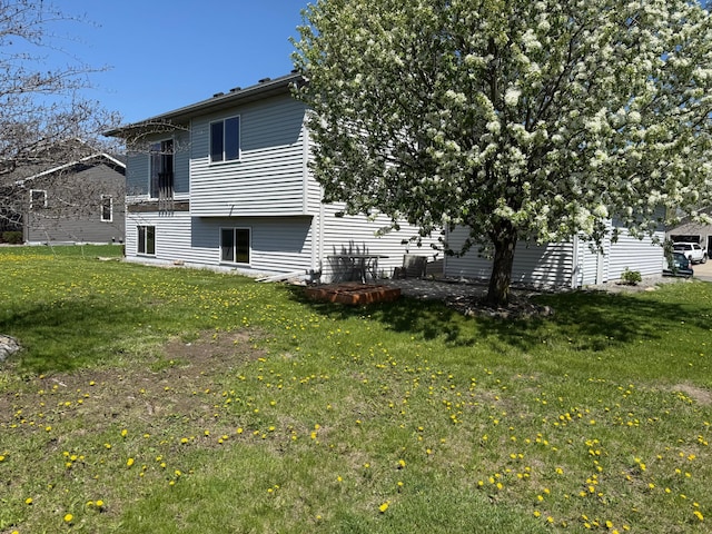 rear view of property featuring a lawn