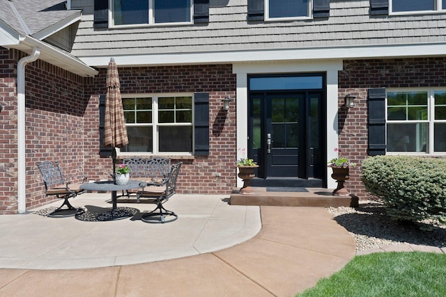 view of exterior entry with brick siding