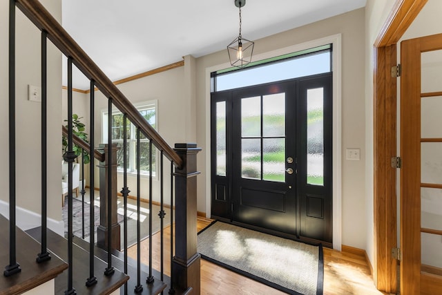 foyer featuring wood finished floors, baseboards, and stairs