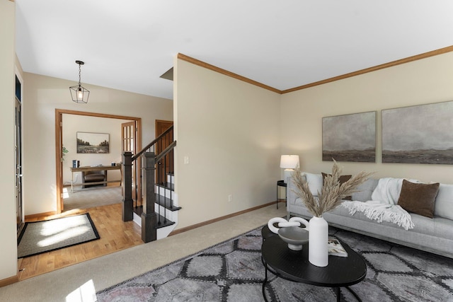 carpeted living room with stairway, baseboards, ornamental molding, and wood finished floors