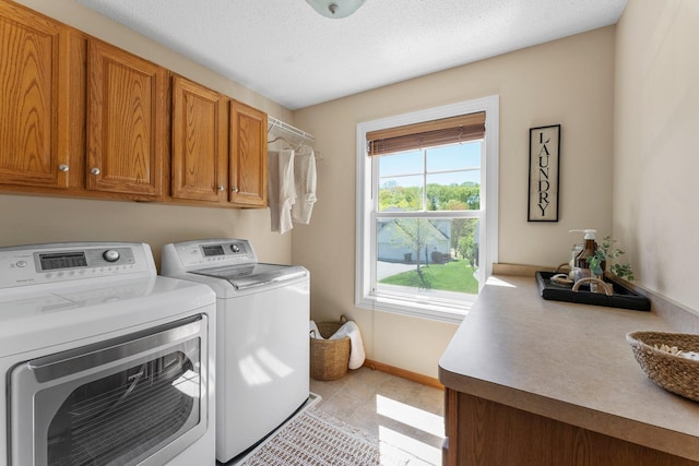 laundry area featuring cabinet space, washing machine and dryer, baseboards, and light tile patterned flooring