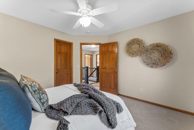bedroom with light carpet, baseboards, and a ceiling fan