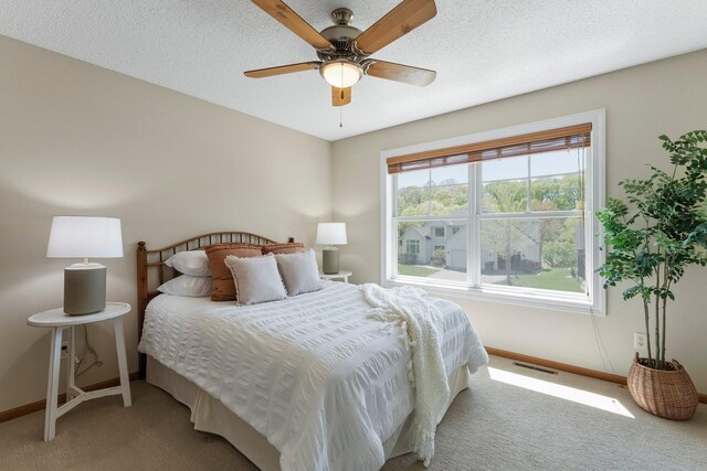 bedroom featuring baseboards, light carpet, and ceiling fan