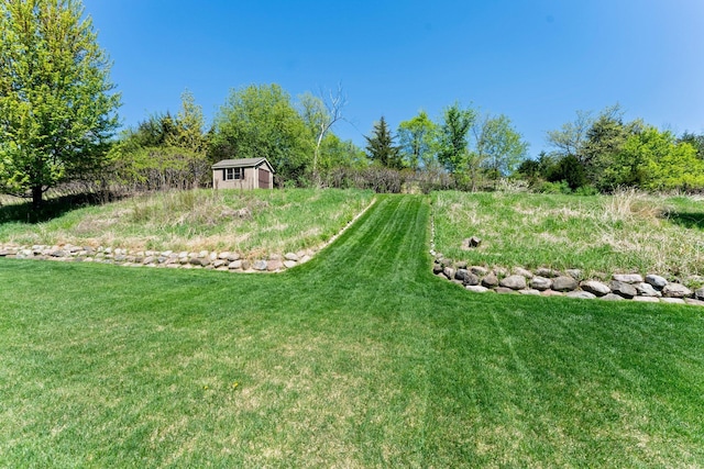 view of grassy yard with a storage shed and an outdoor structure