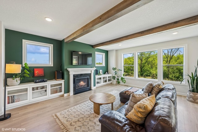 4738 Maas Ct, Minnetrista, MN 55375 - living room featuring a glass covered fireplace, beamed ceiling, wood finished floors, baseboards, and recessed lighting
