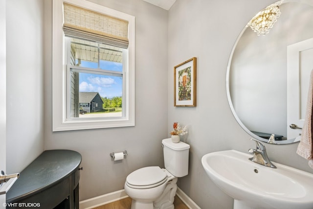 4738 Maas Ct, Minnetrista, MN 55375 - bathroom featuring a sink, toilet, baseboards, wood finished floors, and a chandelier