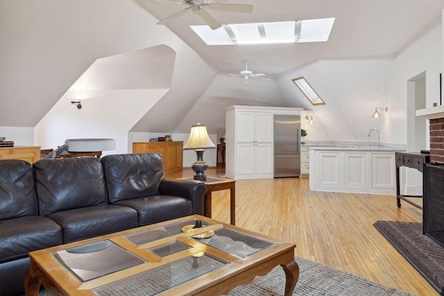 1203 Mount Curve Ave, Minneapolis, MN 55403 - living area featuring a ceiling fan, lofted ceiling with skylight, and light wood-style floors