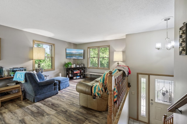 14250 Upper 54th St N, Oak Park Heights, MN 55082 - living area with a chandelier, wood finished floors, and a textured ceiling