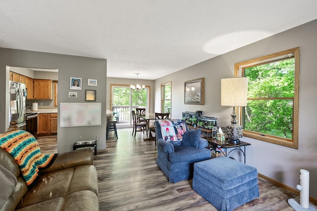 14250 Upper 54th St N, Oak Park Heights, MN 55082 - living area with a chandelier, wood finished floors, a textured ceiling, and baseboards
