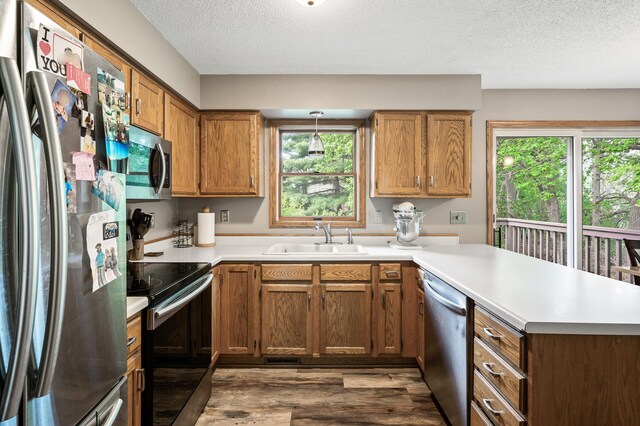 14250 Upper 54th St N, Oak Park Heights, MN 55082 - kitchen featuring stainless steel appliances, a sink, a peninsula, dark wood-style floors, and a textured ceiling
