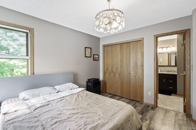 14250 Upper 54th St N, Oak Park Heights, MN 55082 - bedroom featuring wood finished floors, a closet, ensuite bathroom, and a sink