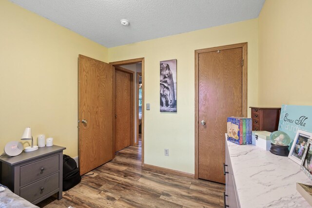 14250 Upper 54th St N, Oak Park Heights, MN 55082 - bedroom featuring wood finished floors, a textured ceiling, and baseboards