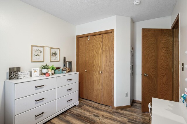 14250 Upper 54th St N, Oak Park Heights, MN 55082 - bedroom featuring dark wood-style flooring, a textured ceiling, baseboards, and a closet