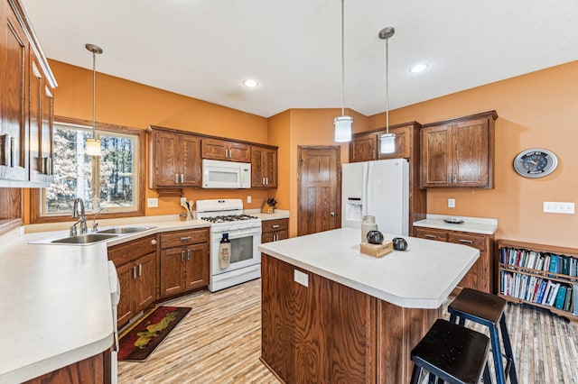 kitchen with hanging light fixtures, a sink, white appliances, light countertops, and a kitchen island