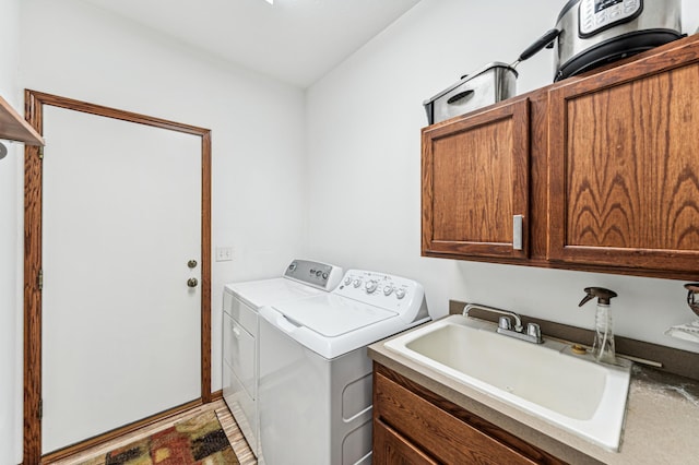 washroom with a sink, separate washer and dryer, and cabinet space