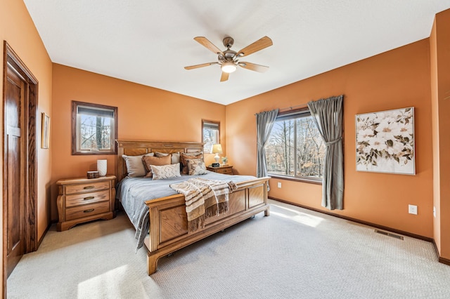 bedroom with light colored carpet, multiple windows, visible vents, and baseboards