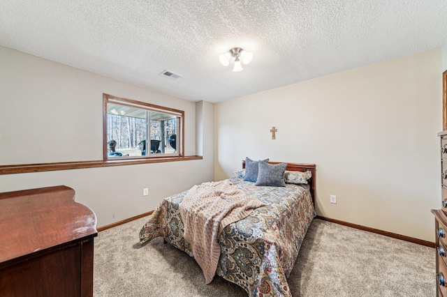 bedroom featuring a textured ceiling, carpet, baseboards, and visible vents