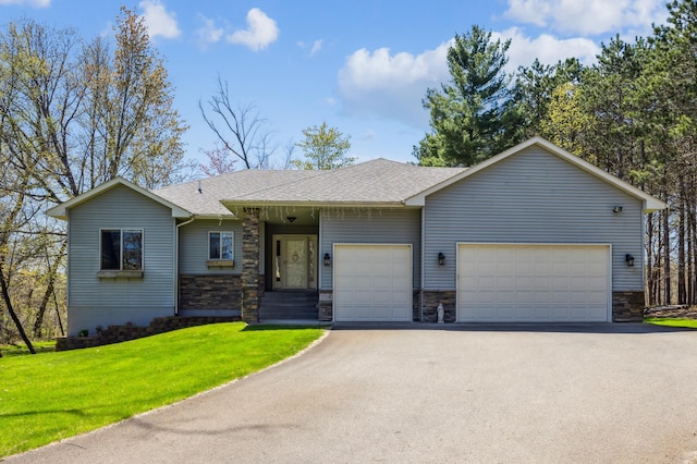 ranch-style home with an attached garage, stone siding, a shingled roof, a front yard, and aphalt driveway