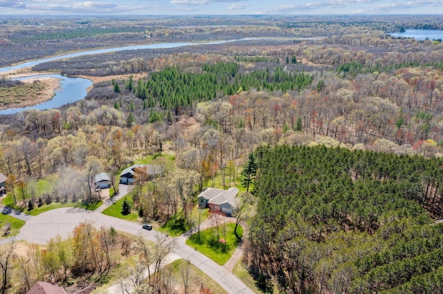 drone / aerial view featuring a water view and a wooded view