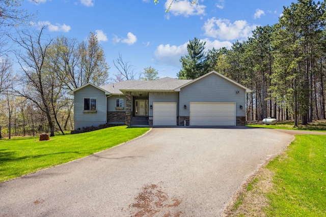 ranch-style home featuring stone siding, aphalt driveway, an attached garage, and a front yard